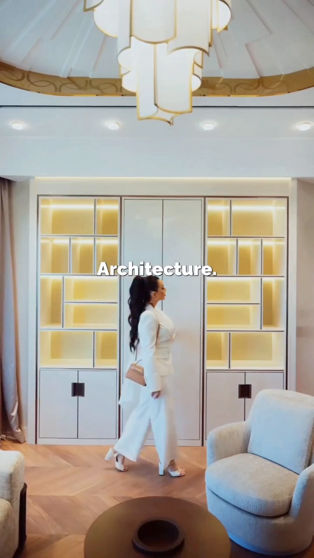 Woman in a white suit in a luxury interior with the Architecture caption, from the Antonovich Group design and build video