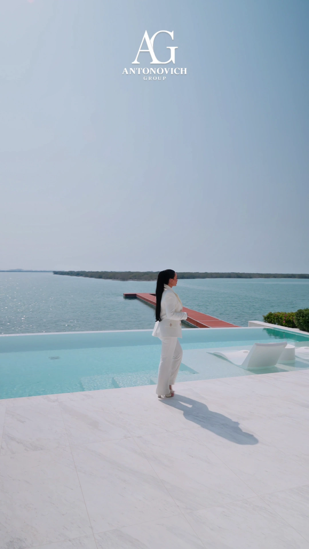 Infinity pool overlooking the water at a private villa landscaped by Antonovich Group