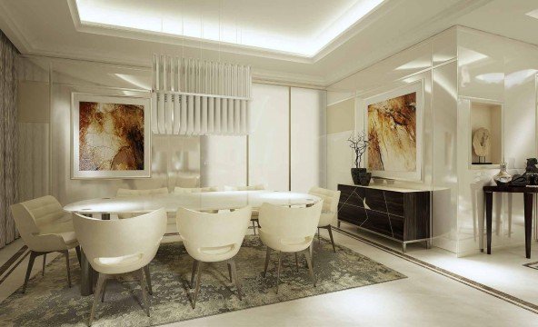 A modern, contemporary living room featuring an L-shaped white couch, a white armchair, a black coffee table with a glass working surface, and a grey rug.