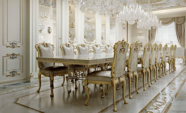 This picture shows a human hand holding a white cup filled with coffee. It appears to be taken from the perspective of someone sitting in a chair, looking up at the hand. The background is blurred and only the coffee cup and hand are in focus.