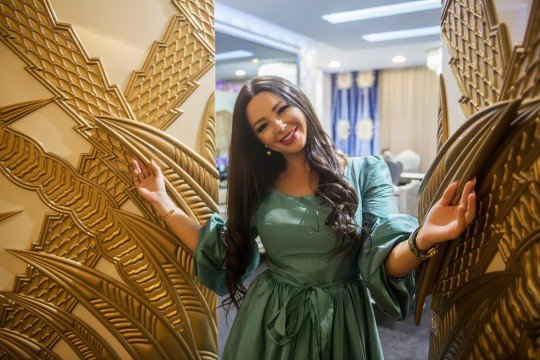 This picture shows a small white puppy sleeping and cuddled up in a blue blanket. The puppy looks peaceful and content as it snuggles up in the blanket.