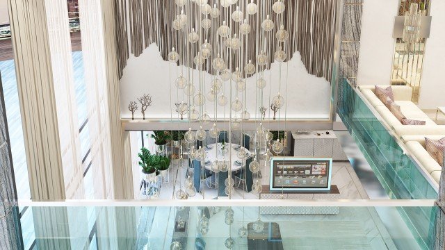 This picture shows a person wearing a blue winter coat, standing in front of a tall tufted snow-covered mountain. The person is wearing dark sunglasses and has a bright red and white striped scarf wrapped around their neck. There is also a flock of birds flying in the distance.