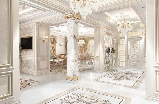 This is a picture of a small white cottage house with a red door and green shutters, situated in a grassy meadow full of wildflowers. The sky is bright blue and there appears to be a mountain in the background.