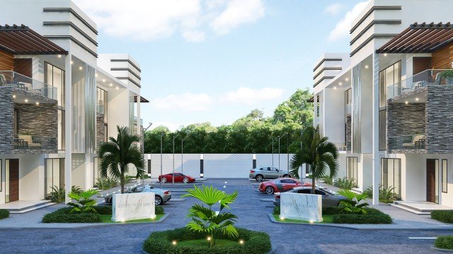 This picture shows a luxurious, contemporary living room with a unique feature wall. The feature wall is painted a deep turquoise, which stands out against the white and light gray walls around it. The room has an elegant cream sofa set and a modern glass coffee table in the center. There is a large white floor lamp in the corner, and the room has plenty of warm lighting to create a cozy atmosphere.