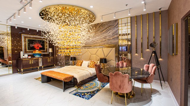 Woman wearing a traditional Russian folk costume posing holding a bouquet of flowers.