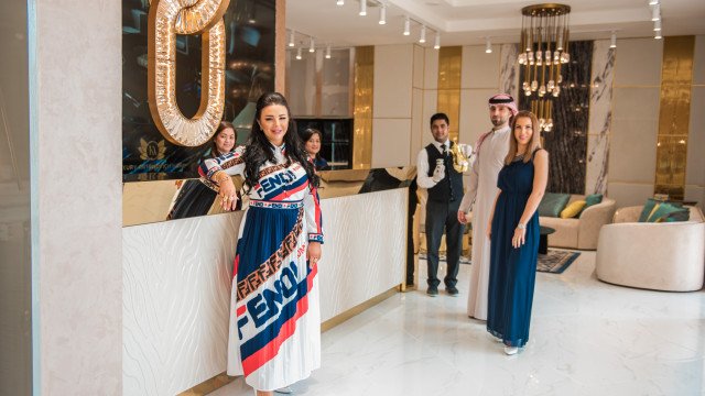 Modern white kitchen with a large center island, stainless steel appliances, and black countertops.