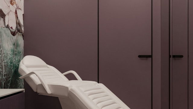 The picture shows a luxurious living room, designed by Antonovich Design. It has beautiful elaborate furniture including a large comfortable sofa with several cushions, two elegant armchairs, and a coffee table. The walls are decorated with ornate wall hangings and paintings in classic gold frames. A white marble fireplace and grand crystal chandelier give the room a luxurious atmosphere.