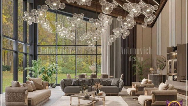 This picture shows a modern interior design, featuring a white sofa, black and white chairs, and a light grey rug. There is a large wall-mounted television, as well as several smaller accent pieces, such as a round coffee table, standing lamps, and a grey credenza in the background. The overall design is minimalist and contemporary, with clean lines and subtle pops of color.