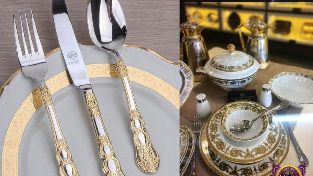 The picture shows a modern living room design with a contemporary black sofa, white armchair, and a large window allowing natural light to flood in. The walls are painted a neutral gray color and several wooden pieces of furniture, such as the coffee table and side table, provide additional seating and storage options. A large abstract painting hangs on the wall, adding a pop of color and texture to the room.