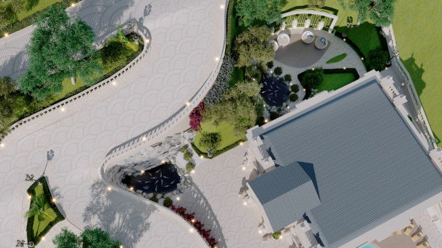 This picture is of a spacious, modern living room decorated in neutral tones. The walls are painted white and the furniture is mostly cream or beige colored. There is an L-shaped sectional couch with a curved accent table behind it, two armchairs on either side of a round coffee table, and an ottoman in the center of the room. A fireplace is located on one wall, while a large window lets in natural light on the opposite wall. An elegant chandelier hangs from the ceiling, illuminating the space.