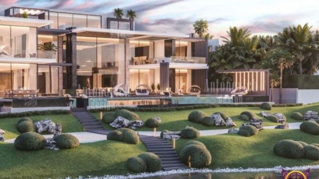 This picture shows a contemporary style living room decorated with plush white furniture, modern art, and warm wood accents. The walls are painted in a light gray with white trims, while the ceiling features recessed lighting. The center of the room is occupied by a white, round rug featuring spiral designs, and the space is populated with various pieces of modern, abstract art. In the corner of the room, two small, green plants lay perched atop a golden table, adding a touch of nature to the otherwise modern home.