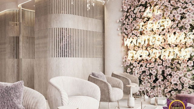 Modern luxury interior featuring a curved cream sofa, a black armchair and ottoman, a round marble coffee table, a patterned floor rug, and a large hanging chandelier.