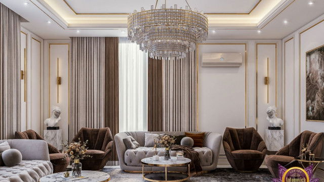 This picture shows a luxurious interior design featuring a large living room with a grand chandelier and two ornately decorated sofas. The walls are painted a deep red, and the carpeting is a richly colored rug. The room is decorated with a marble-topped side table, and a beautiful fire place with a carved wooden mantle. The windows are draped with ornate drapery, and the area is accented with plants and artwork.