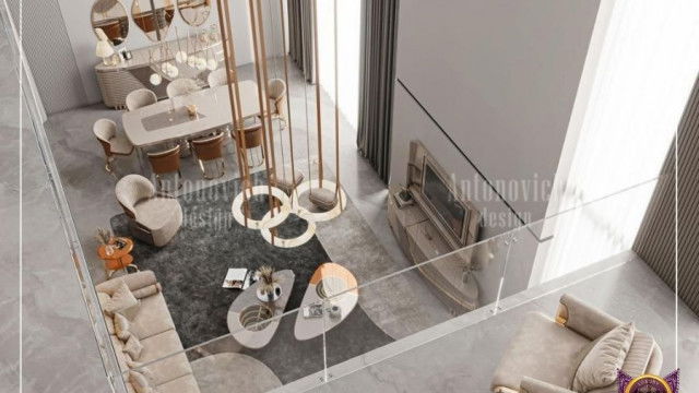 This picture shows a modern, stylish living room. The room features a large, white sectional sofa and an ottoman in the center of the room. The walls are adorned with abstract artwork, and there is a contemporary black marble fireplace mantel with a wall-mounted television above it. Two oversized windows allow natural light to fill the room, and the wood flooring adds warmth to the design. Lastly, there is a blue rug to tie all the elements together.