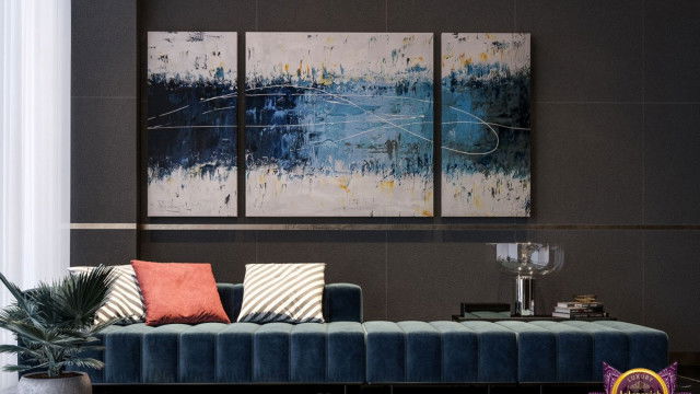 This picture is an interior design rendering of a modern living room. The room features a stylish wall paneling in a beige color, with built-in shelving and window treatment in a light gray color. In the center of the room is a white sofa with two matching armchairs, and several colorful decorative pillows for accent. There are also two round end tables with brass accents on either side of the sofa. The entire space is illuminated with several ornate wall sconces and a round pendant light.