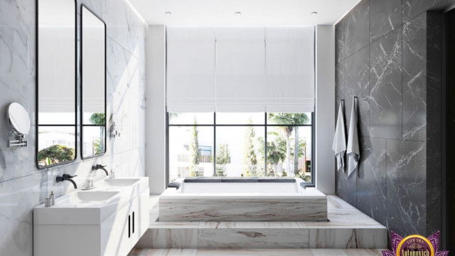 A large entryway featuring a tall double door with ornate carvings, flanked by two tall stone columns and an intricate stone arch.