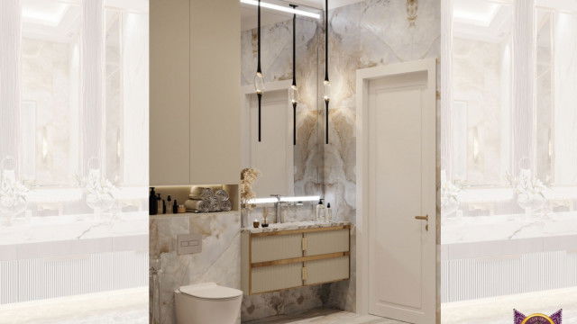 This picture is showing an elegant, beige-toned room with many luxurious features. There is a large stone fireplace, a large chandelier with matching wall sconces, and a plush beige sofa with white pillows. The walls have intricate patterned wallpaper and the ceiling has a light-colored trim. There are several pieces of bold artwork hanging on the walls, as well as shelves and other decorative items. In the center of the room there is a cozy seating area with an ornate coffee table.