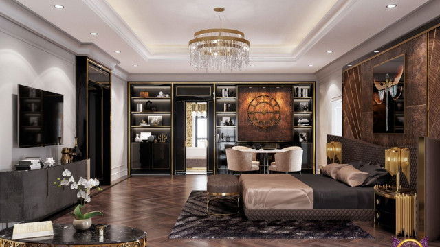 This picture shows a luxurious dining room with a contemporary design. The room features an elaborate chandelier and a large gold mirror hung on the wall. There is a wooden dining table surrounded by red velvet dining chairs, and a buffet cabinet with glass doors. The walls are grey and white, and there is a patterned area rug in the center of the room.