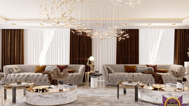 This picture shows a bathroom designed by Antonovich Design. It has light pink walls with a white border, a white sink and countertop, with a black accent wall behind the sink. There is a large glass mirror mounted on the wall above the sink, and there is a grey tile flooring with decorative accents. A small potted plant and a towel rack accent the design.