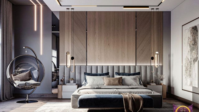 An intricately decorated modern living room with furniture in dark tones, a large white chandelier, and a bright yellow accent wall.