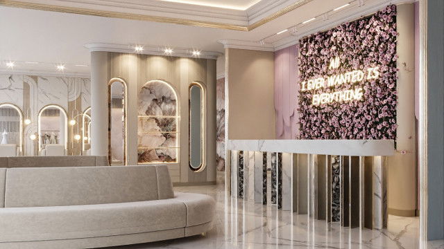 Modern interior featuring a large sectional sofa with white trimmings and beige cushions, a round glass coffee table, and a contemporary wall-mounted fireplace.