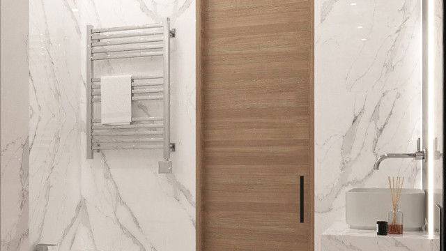 A lush green landscape featuring a body of water, ornamental plants, and a curved stone pathway.