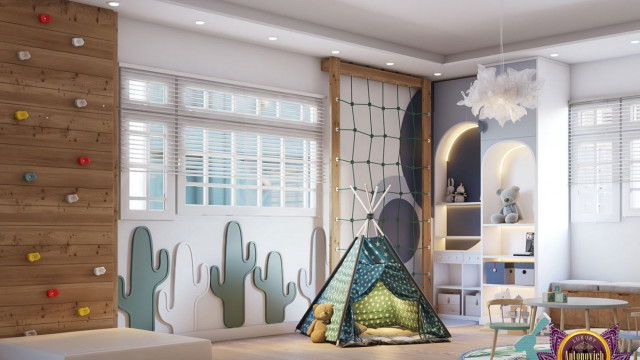 This picture shows a luxurious master bedroom with modern and elegant decor. The room features a corner fireplace, large windows overlooking a cityscape, and a black tufted bed with white linens. A plush gray velvet armchair is placed on the side of the fireplace, along with a white and gold end table. In the background, a grand chandelier hangs from the ceiling, adding the perfect touch of drama to the room.