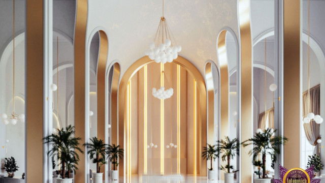 This picture shows a luxurious interior design in a modern home. The room features a white and grey color scheme, with a marble flooring and a large glass window on the wall that overlooks the city skyline. The walls are adorned with beautiful artwork, and the furniture is made of a combination of leather, velvet and wood. There is also an ornate chandelier that hangs from the ceiling, giving the space a warm and inviting atmosphere.