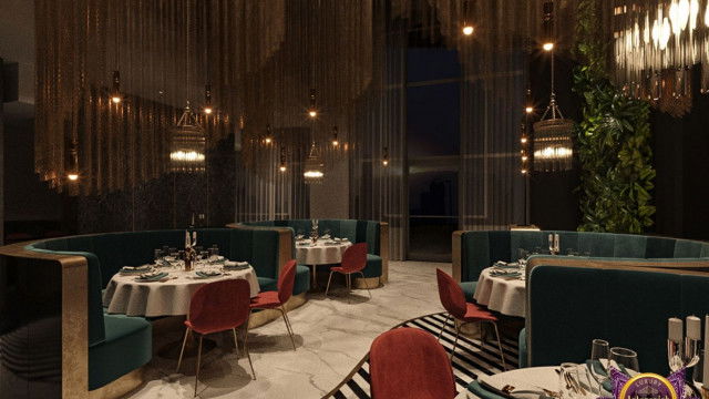 A contemporary interior with a curved seating area, fully upholstered in a luxurious white material with grey geometric arm rests and an ornate patterned throw pillow.