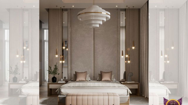 This picture shows an open-concept modern kitchen. It features a glossy white countertop with a built-in cooktop and oven, as well as stainless steel appliances. There is a large island in the center of the room with a sink and breakfast bar. The walls are painted in a light gray color, and there are wood cabinets and drawers along one wall. A light fixture hangs from the ceiling, providing extra lighting.