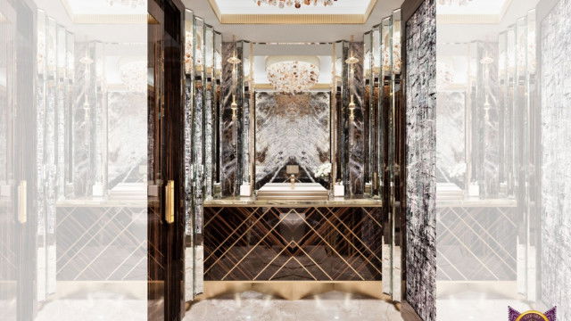 This picture shows an ornately decorated living space filled with antique furniture and grand furnishings. The walls are lined with luxurious striped wallpaper and the room is lit by two magnificent chandeliers. In the center of the room is a large, gray velvet sofa with two brown leather armchairs on either side. A mirrored console table sits behind the sofa, flanked by two tall antique vases. The entire scene is completed by a plush area rug that adds a touch of warmth to the room.