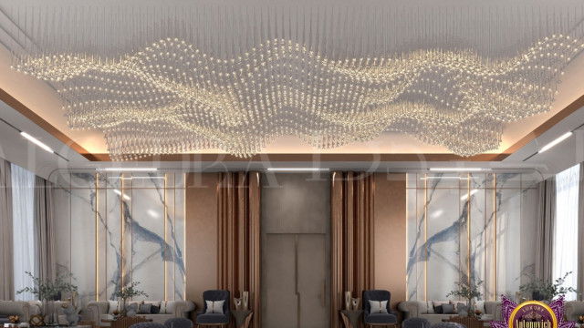 The picture shows a luxurious modern living room. The walls are painted white, with a grey sofa situated in the center of the room. There is a round coffee table in front of the sofa and two armchairs on either side. The armchairs are upholstered with a patterned fabric and have a unique curved shape. On either side of the living room are tall windows that bring in plenty of natural sunlight. A black marble fireplace is set into the wall and a beautiful framed artwork hangs above it.