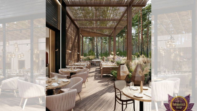 This picture shows a luxurious interior home design with modern and traditional elements. There is an impressive grand staircase leading to the second floor, with a beautiful crystal chandelier hanging from the ceiling above. The walls are painted in a muted gray color and detailed with white crown molding. The floor is covered in a light gray carpet, and to one side of the staircase is a large black marble fireplace flanked with two stylish chairs.