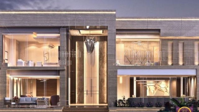 This picture shows an interior hallway space inside a modern home. This hallway is decorated with attractive contemporary elements. The walls are covered in a light beige wallpaper and the floor is tiled with grey stones. There are two large glass windows that allow natural light to enter the room, making it feel bright and airy. A wooden door is on the right side of the hallway, while an oversized mirror is located on the left. On the far wall, there is a stunning painting which adds a touch of elegance to the space.