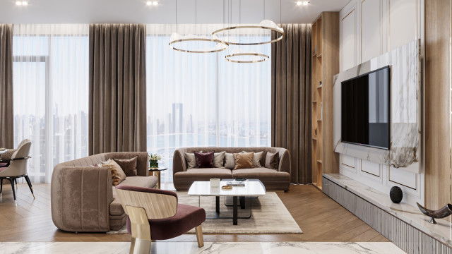 This picture shows a grand and luxurious living room with a large central sitting area. The walls are covered in a warm beige wallpaper and crown molding, and in the center of the room is a white marble fireplace. There is a large flat-screen television mounted on the wall above the fireplace, and a large curved leather sofa with several woven rattan accent chairs facing it. The neutral colors and plush furnishings make this living room perfect for cozy evenings spent with family or friends.