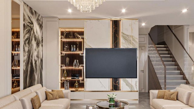 This picture shows a modern, contemporary living room. The design includes ornate blue velvet couches, a luxurious chandelier, and two end tables with interesting geometric patterns. The walls are painted in an elegant grey color, and the large windows provide plenty of natural light. The bright white rug adds contrast to the overall design and gives the room a clean and airy feel.