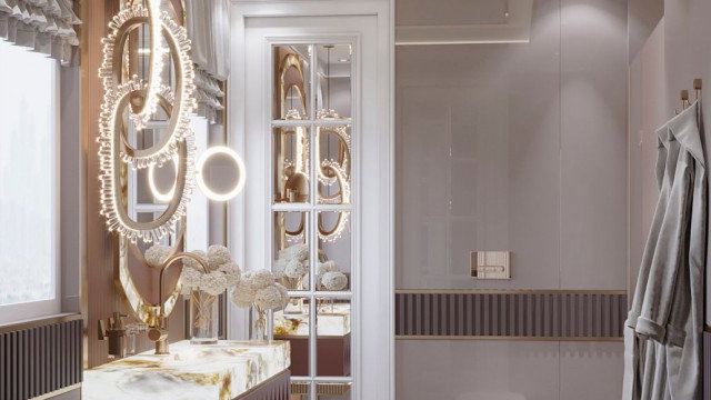 A luxury white and gold kitchen featuring marble countertops, high-end appliances, and ornate detailing.