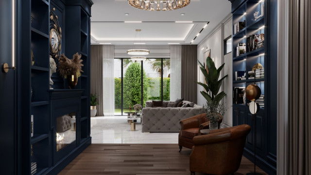 The picture shows a luxurious living room with two large burgundy sofas, two chairs, a large glass coffee table, and an ornate gold mirror set on the wall. The walls are painted a deep red color, while the floor is covered with a light-colored wood laminate. There is a round glass chandelier above the seating area and curtains that hang from the ceiling. The overall effect is elegant and sophisticated.