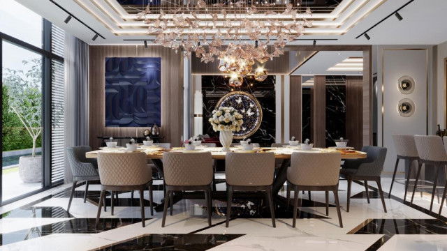 This picture shows an ornate wooden door with intricate carved designs. The door is made of dark wood, and the top is adorned with a large curving arch. On either side of the door are two tall rectangular windows, each with twelve small diamond-shaped panes. There is also a decorative crest or shield above the arch that has a figure of a bird on it. The door itself is surrounded by textured walls with an arched window above.