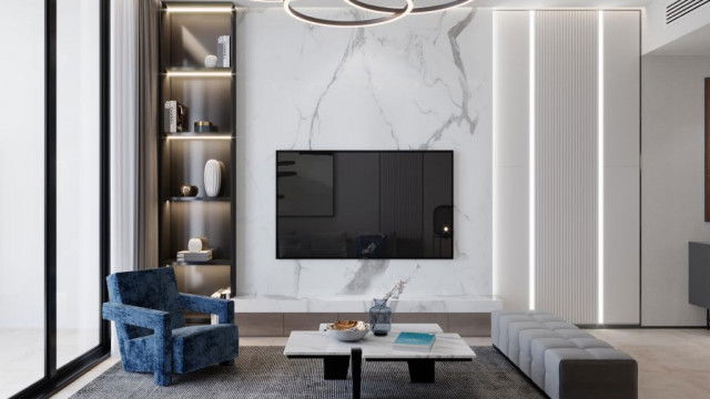 A modern kitchen with stainless steel appliances, light-colored cabinetry, and a marble countertop.