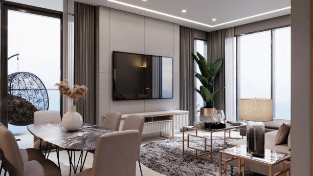 This picture is of a luxurious modern living room. The room features a dark hardwood floor, a grey sectional couch, and a white marble fireplace with a built-in shelving unit. There is also a large abstract painting hanging on the wall and a glass coffee table in front of the couch. The room is well-lit by a chandelier and a few other recessed light fixtures.