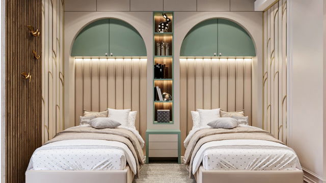 A room with beige walls, a cream sofa and armchair, a geometric rug, and a variety of artwork adorning the walls.