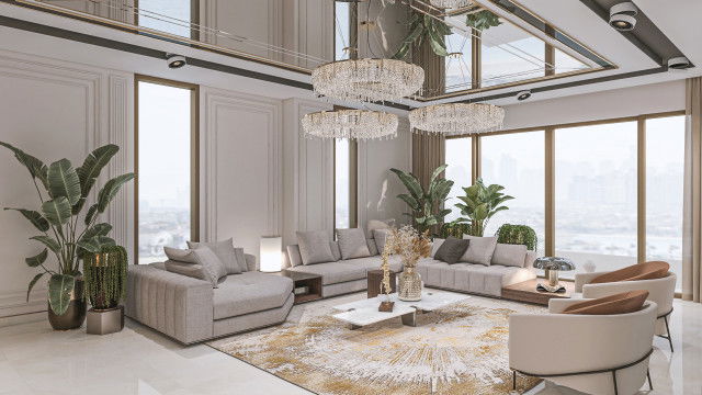 Modern living room interior with white walls, ceiling and light hardwood flooring, grey and blue velvet sofas and ottomans, glass coffee table, artwork on wall, and multiple pendant lights.