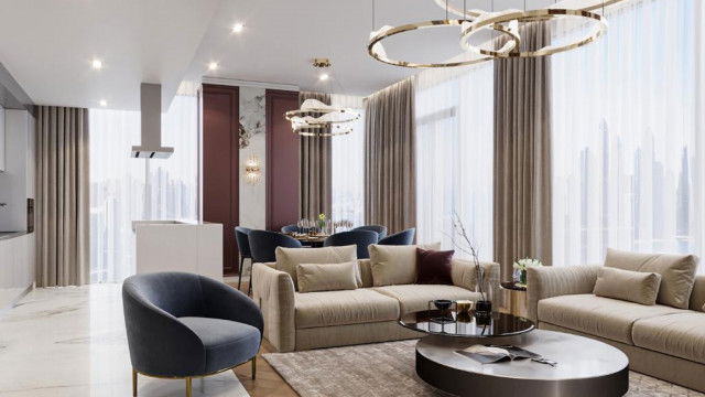 Luxuriously-furnished living room with recessed ceiling, ornate wall sconces, and tall columns on either side of a large fireplace.