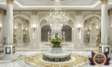 The picture shows a woman and a young girl standing in front of a large red and white wall with a bright pink stripe running down the center. They both have their hands raised, as if they are about to touch the wall, but only the woman's hand is actually touching it. In the background is a line of trees.