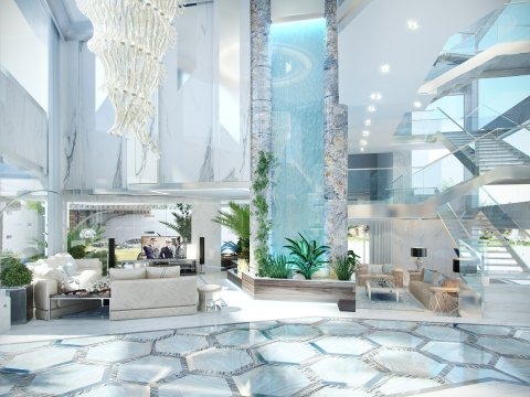 This picture shows a large metallic rocket on a launch pad. The rocket has four bright orange boosters and a long white main body. In the foreground, several technicians and engineers can be seen standing around the launch pad. A few other rockets are visible in the background.