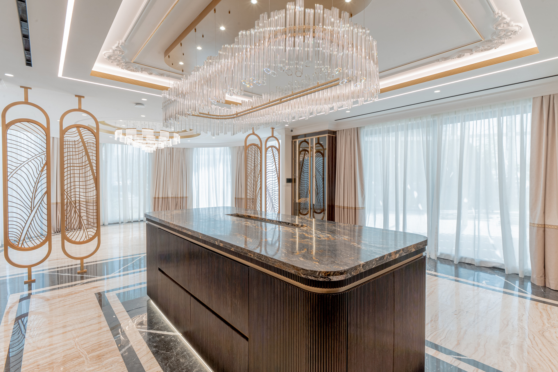 Custom kitchen with a dark wood island, stone worktop and crystal chandelier